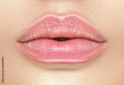 Beautiful young woman's lips closeup, Part of the model girl face, youth concept. Perfect healthy skin. Natural make-up. Health care. 