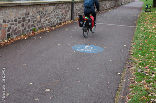 Radfahrer fährt auf einem kombinierten Fußgänger-/ Fahrradweg, Bewegungsunschärfe photo