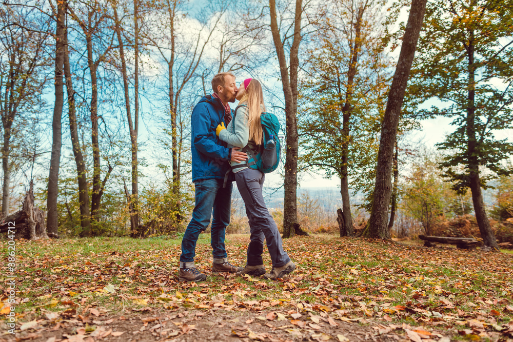 Couple of man and woman kissing during walk in fall Couple of man and woman kissing during walk in fall