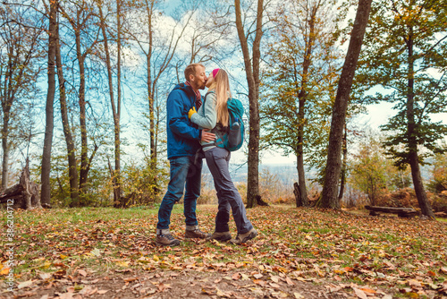 Couple of man and woman kissing during walk in fall