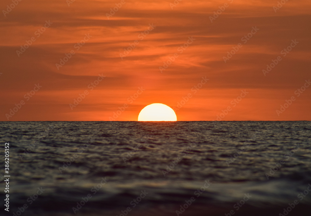  a beautiful sunset on a calm sea with a clear evening sky