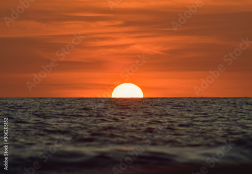 Fototapeta Naklejka Na Ścianę i Meble -   a beautiful sunset on a calm sea with a clear evening sky