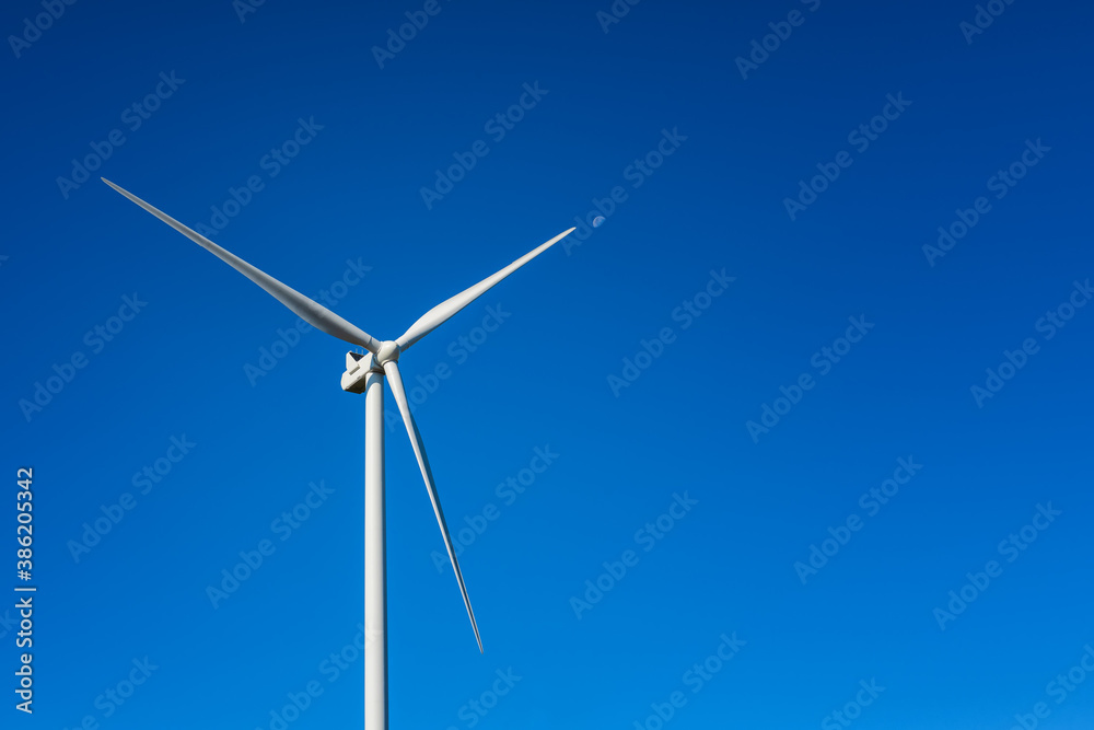 Wind turbines on a beautiful blue sky in a mountain wind farm in Sardinia. Renewable energy concept, green energy generation. Energy industry. Wind turbines on a beautiful blue sky in a mountain wind farm in Sardinia. Renewable energy concept, green energy generation. Energy industry.