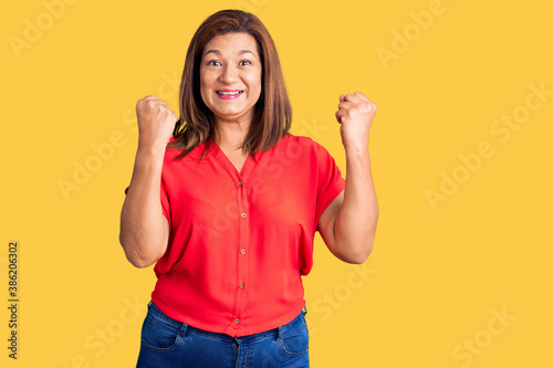 Photographie Middle age latin woman wearing casual clothes screaming proud, celebrating victo