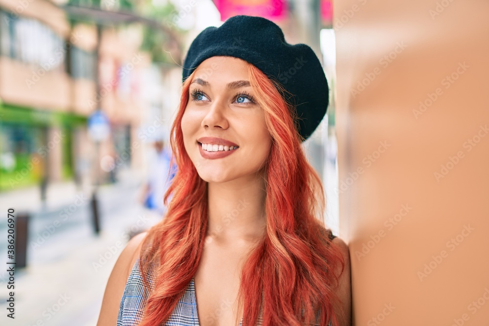 Young redhead girl wearing french style leaning on the wall at the city Young redhead girl wearing french style leaning on the wall at the city