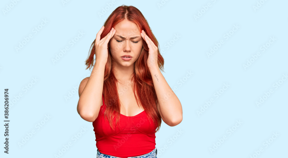 Young redhead woman wearing casual clothes with hand on head for pain in head because stress. suffering migraine.