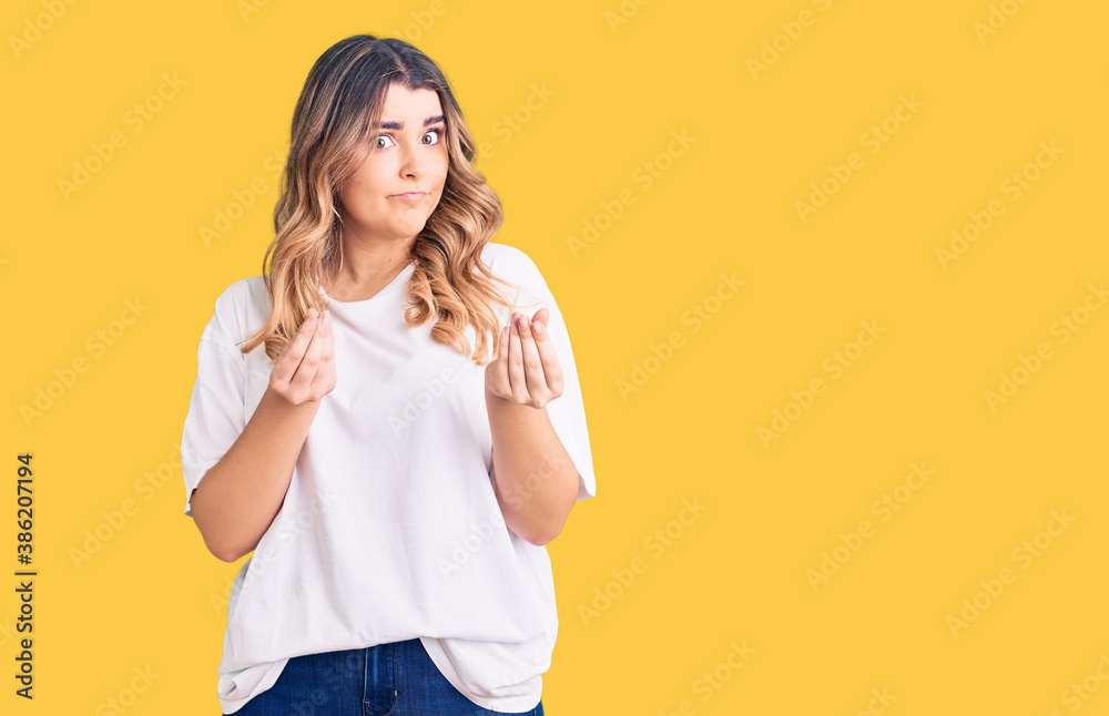 Young caucasian woman wearing casual clothes doing money gesture with hands, asking for salary payment, millionaire business Young caucasian woman wearing casual clothes doing money gesture with hands, asking for salary payment, millionaire business