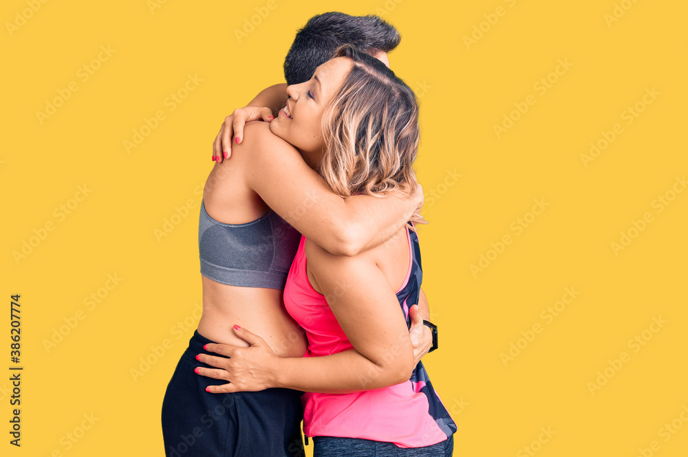 Couple of women wearing sportswear hugging oneself happy and positive from backwards. self love and self care Couple of women wearing sportswear hugging oneself happy and positive from backwards. self love and self care