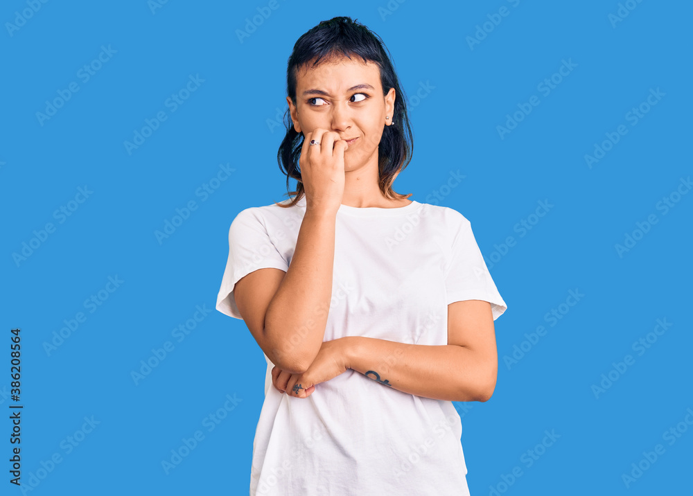 Young woman wearing casual clothes looking stressed and nervous with hands on mouth biting nails. anxiety problem. Young woman wearing casual clothes looking stressed and nervous with hands on mouth biting nails. anxiety problem.
