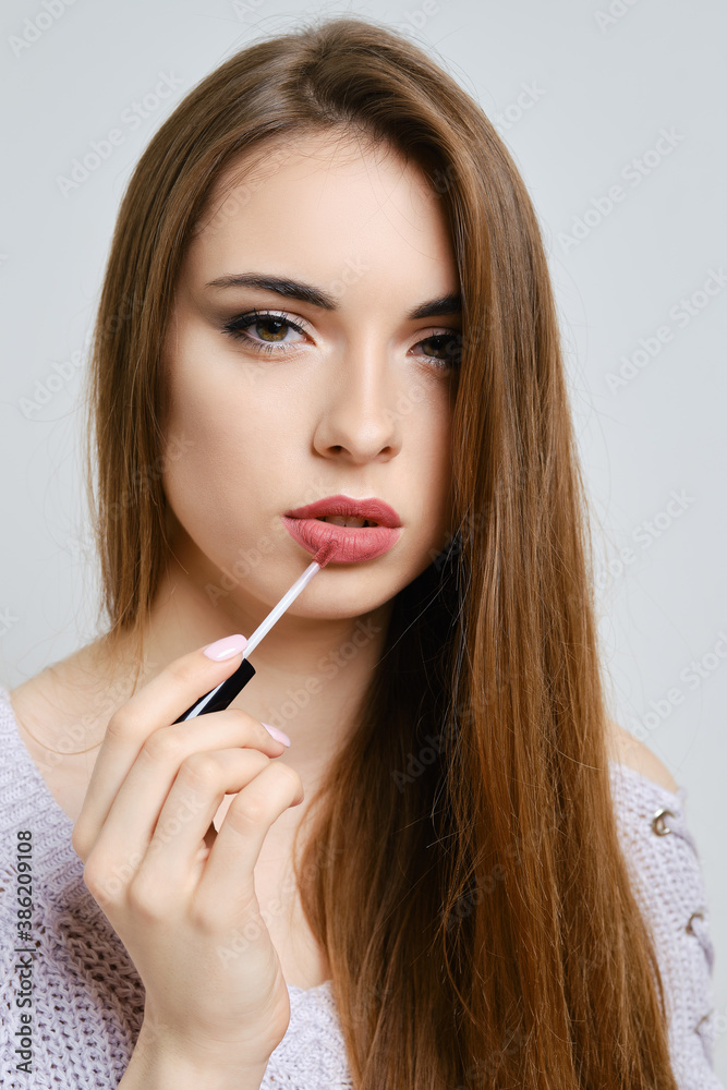 portrait of beautiful woman applying liquid lipstick portrait of beautiful woman applying liquid lipstick