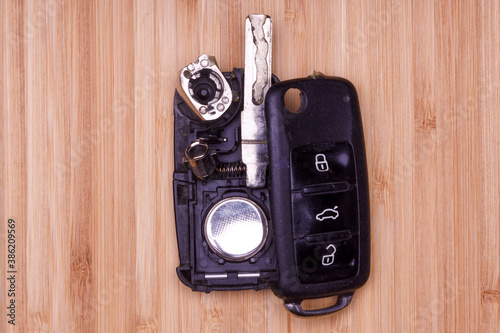 Broken Or Damaged Remote Key Fob On Wooden Background. Remote Key Fob Of Any Vehicle Car Locksmith Service.