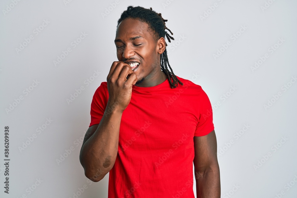 African american man with braids wearing casual clothes looking stressed and nervous with hands on mouth biting nails. anxiety problem. African american man with braids wearing casual clothes looking stressed and nervous with hands on mouth biting nails. anxiety problem.