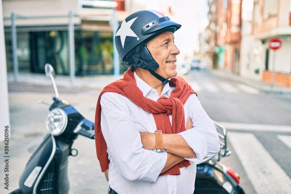 Senior motorcyclist man smiling happy wearing moto helmet at the city. Senior motorcyclist man smiling happy wearing moto helmet at the city.