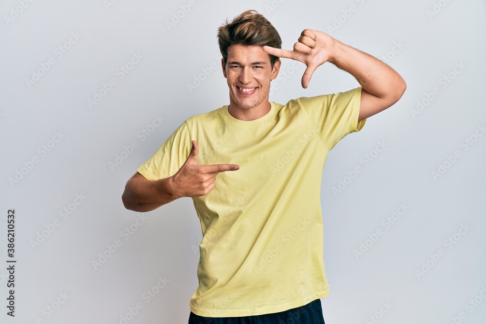 Handsome caucasian man wearing casual clothes smiling making frame with hands and fingers with happy face. creativity and photography concept. Handsome caucasian man wearing casual clothes smiling making frame with hands and fingers with happy face. creativity and photography concept.