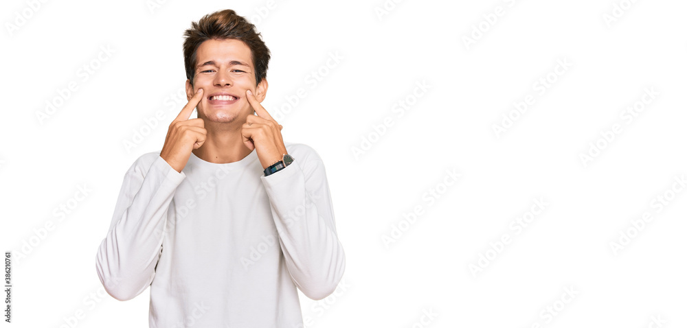 Handsome caucasian man wearing casual white sweater smiling with open mouth, fingers pointing and forcing cheerful smile Handsome caucasian man wearing casual white sweater smiling with open mouth, fingers pointing and forcing cheerful smile