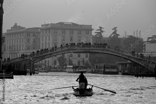 Venice, Italy, December 28, 2018 evocative black and white image of gondolas moving in a canal © massimo