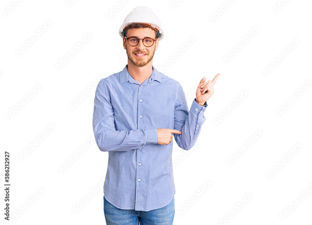 Handsome young man with bear wearing architect hardhat smiling happy pointing with hand and finger to the side Handsome young man with bear wearing architect hardhat smiling happy pointing with hand and finger to the side