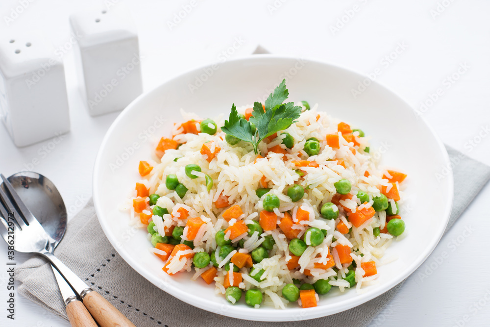 Boiled rice with vegetables on a plate, traditional Asian dish Boiled rice with vegetables on a plate, traditional Asian dish