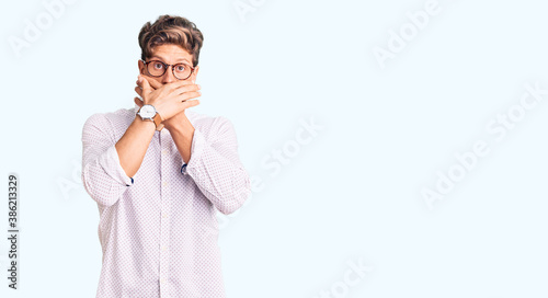 Foto Young handsome man wearing business clothes and glasses shocked covering mouth with hands for mistake