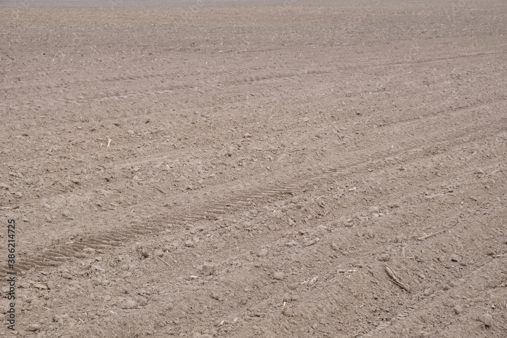 A plowed agricultural field. Fertile cultivated soil in the farm field. A plowed agricultural field. Fertile cultivated soil in the farm field.
