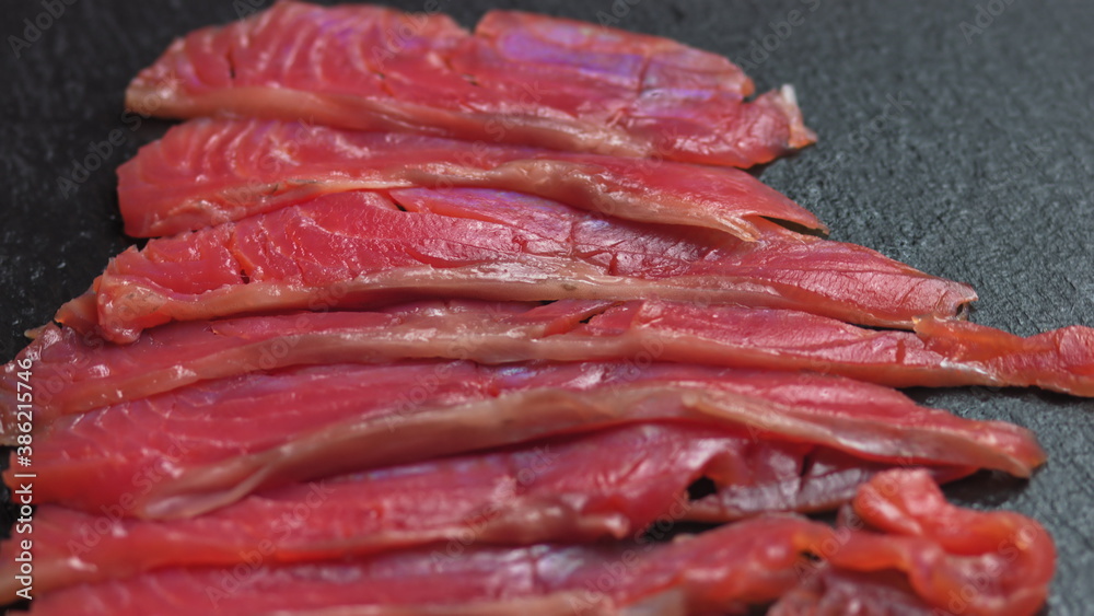 Close up shot of smoothly rotating salmon, Sushi cooking process - Philadelphia, burning fire smoking fresh raw red tuna salmon eel Close up shot of smoothly rotating salmon, Sushi cooking process - Philadelphia, burning fire smoking fresh raw red tuna salmon eel