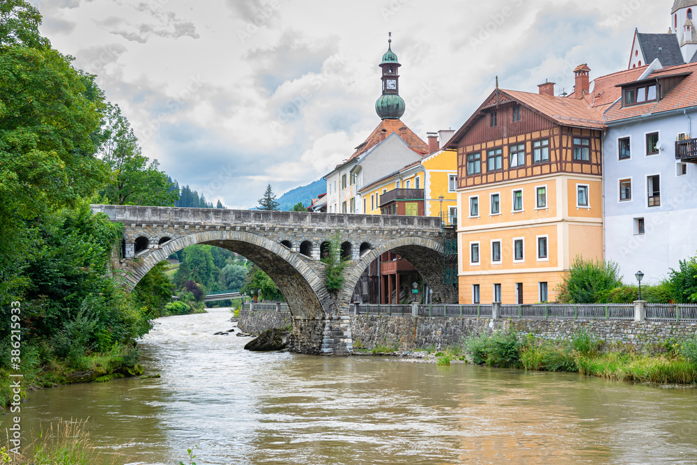 Arch bridge over river Mur in historic town of Murau in central eastern Alps, Austria