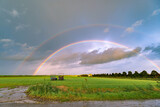 Bright and colorful double rainbow over green landscape
