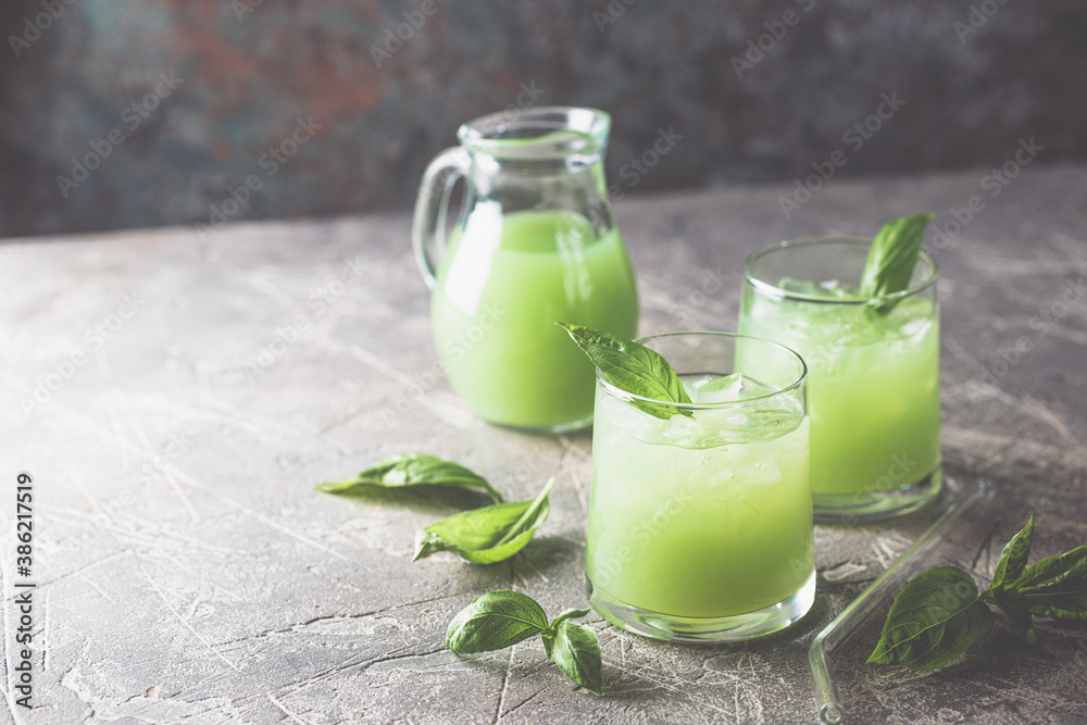Cold basil lemonade refreshing summer drink on gray background Cold basil lemonade refreshing summer drink on gray background