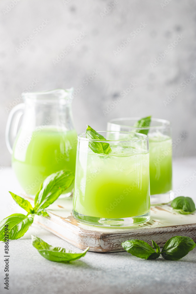 Cold basil lemonade refreshing summer drink on gray background Cold basil lemonade refreshing summer drink on gray background