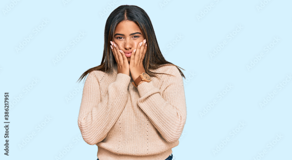 Young latin girl wearing wool winter sweater tired hands covering face, depression and sadness, upset and irritated for problem Young latin girl wearing wool winter sweater tired hands covering face, depression and sadness, upset and irritated for problem
