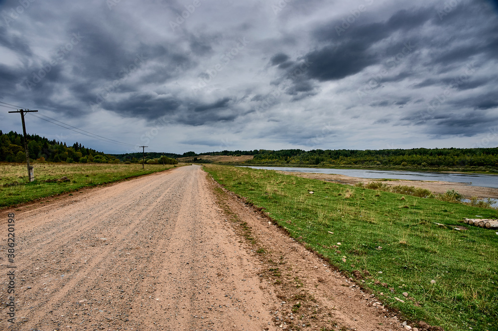 Forest dirt road in the wilderness along the river Forest dirt road in the wilderness along the river