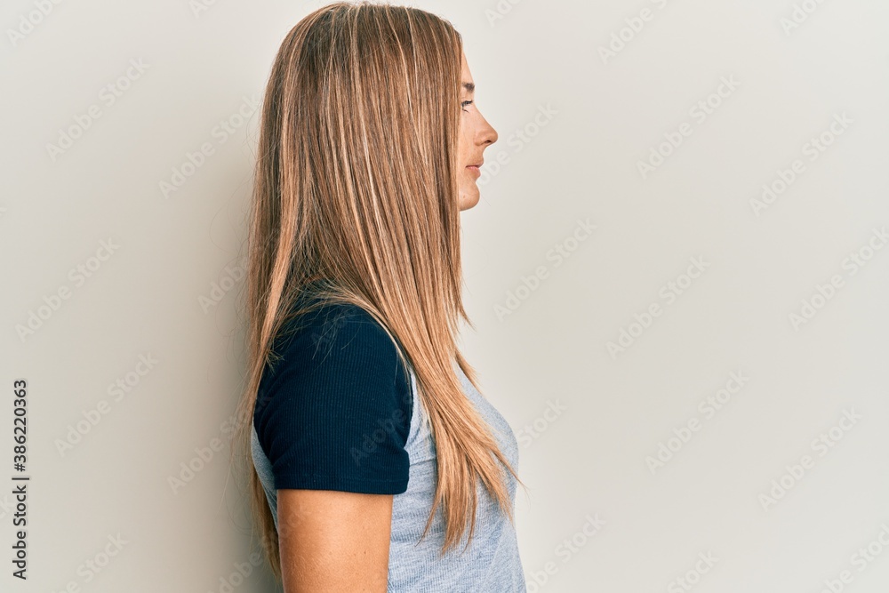 Young blonde woman wearing casual clothes looking to side, relax profile pose with natural face with confident smile. Young blonde woman wearing casual clothes looking to side, relax profile pose with natural face with confident smile.