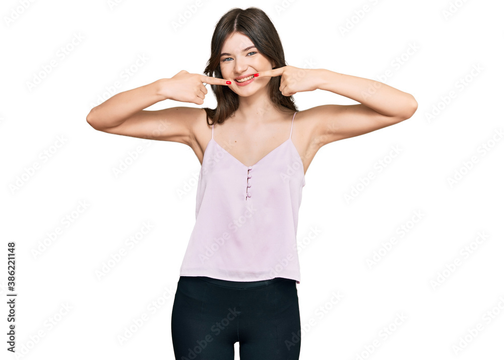Young beautiful caucasian girl wearing casual clothes smiling cheerful showing and pointing with fingers teeth and mouth. dental health concept. Young beautiful caucasian girl wearing casual clothes smiling cheerful showing and pointing with fingers teeth and mouth. dental health concept.