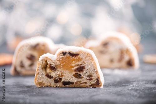 Christstollen, traditonal christmas cake with nuts, raisons, marzipan on a blue background, empty space for text photo