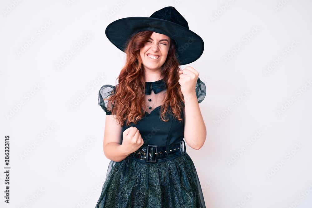 Young beautiful woman wearing witch halloween costume celebrating surprised and amazed for success with arms raised and eyes closed. winner concept. Young beautiful woman wearing witch halloween costume celebrating surprised and amazed for success with arms raised and eyes closed. winner concept.
