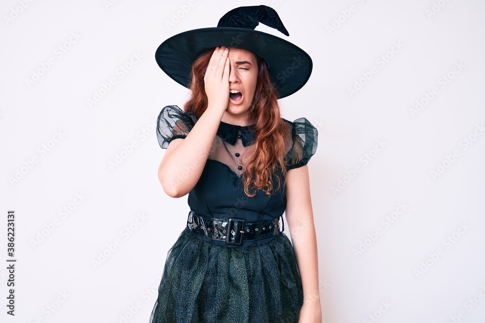 Young beautiful woman wearing witch halloween costume yawning tired covering half face, eye and mouth with hand. face hurts in pain. Young beautiful woman wearing witch halloween costume yawning tired covering half face, eye and mouth with hand. face hurts in pain.