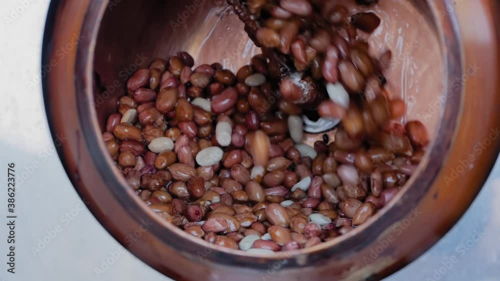 Professional nut roaster machine for mixing, roasting and glazing peanuts: close up, slow motion. Production, manufacturing, preparation, technology and street food concept Professional nut roaster machine for mixing, roasting and glazing peanuts: close up, slow motion. Production, manufacturing, preparation, technology and street food concept