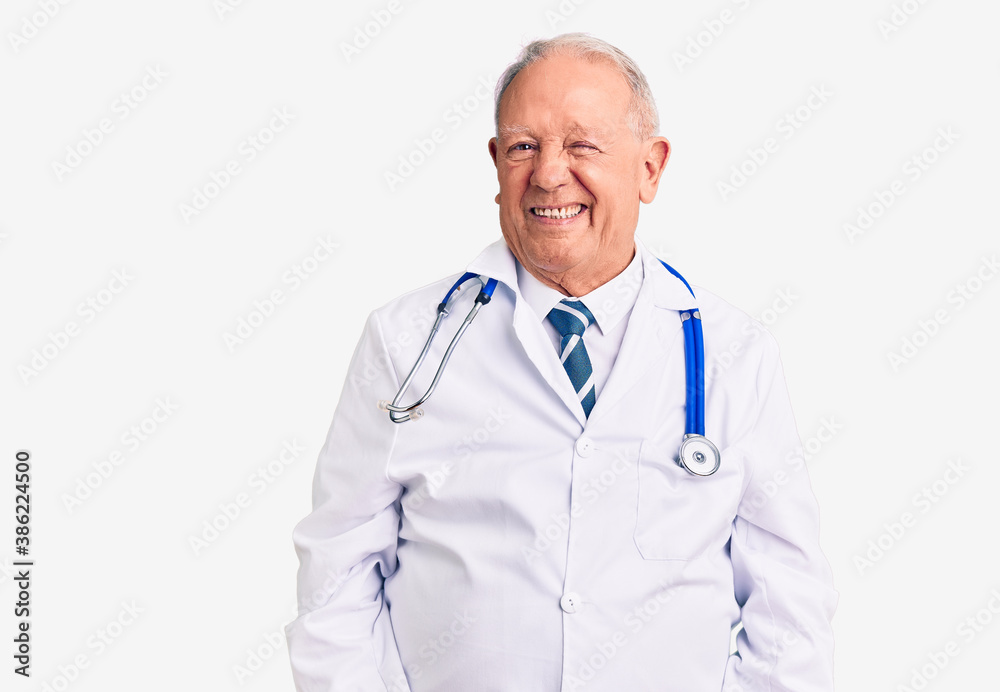 Senior handsome grey-haired man wearing doctor coat and stethoscope winking looking at the camera with sexy expression, cheerful and happy face. Senior handsome grey-haired man wearing doctor coat and stethoscope winking looking at the camera with sexy expression, cheerful and happy face.