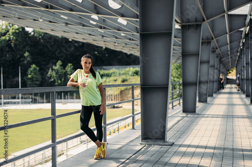Motivated woman relaxing after morning workout at stadium