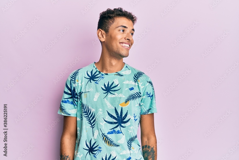 Young handsome african american man wearing summer style looking to side, relax profile pose with natural face and confident smile. Young handsome african american man wearing summer style looking to side, relax profile pose with natural face and confident smile.