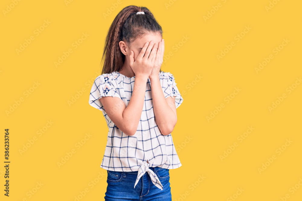 Cute hispanic child girl wearing casual clothes with sad expression covering face with hands while crying. depression concept.