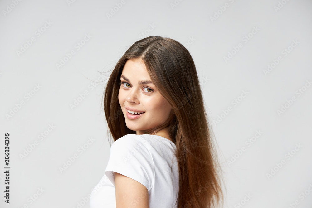 beautiful brunette with long hair smiling on a light background beautiful brunette with long hair smiling on a light background