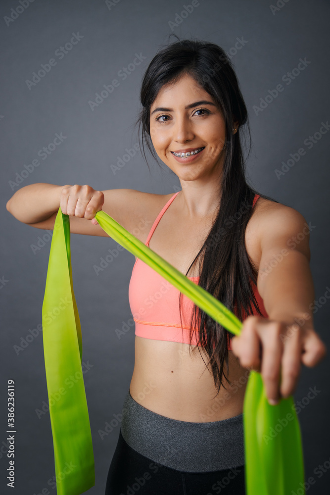 Retrato de joven mujer mexicana haciendo ejercicio con ligas Retrato de joven mujer mexicana haciendo ejercicio con ligas