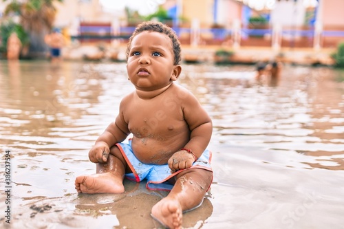 Adorable african american toddler sitting at the beach.
