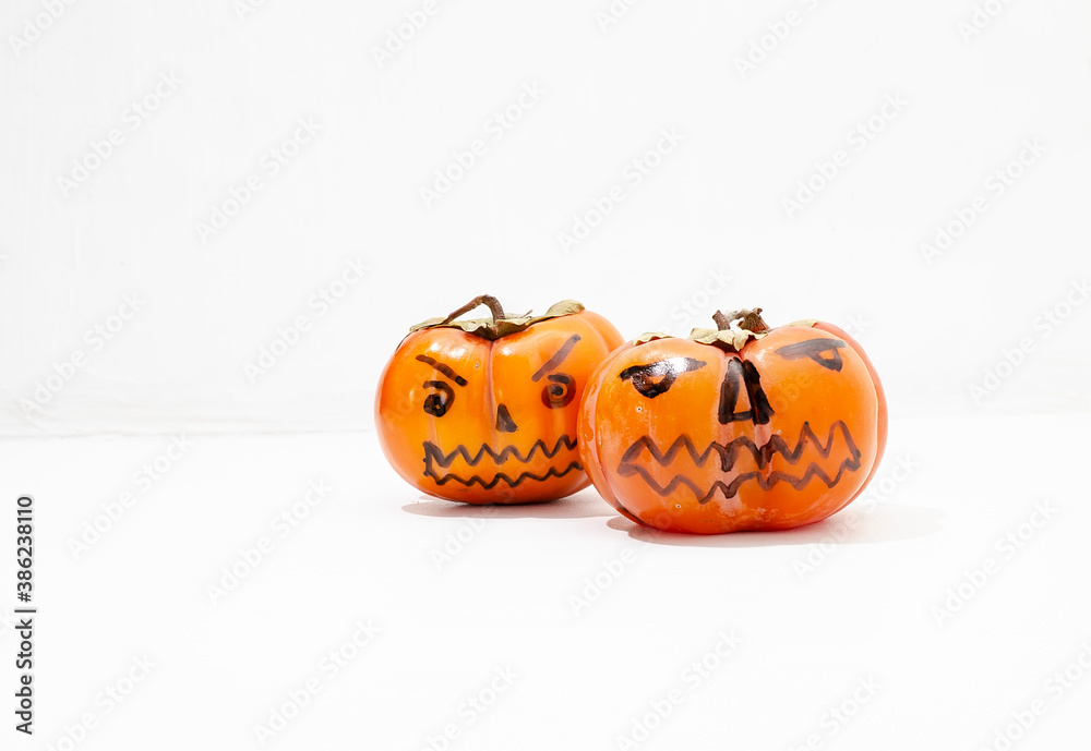 Jack - o ' - lantern, Halloween monsters - muzzles drawn on persimmon fruit. Persimmon is very similar to a pumpkin, the same orange and cheerful.
