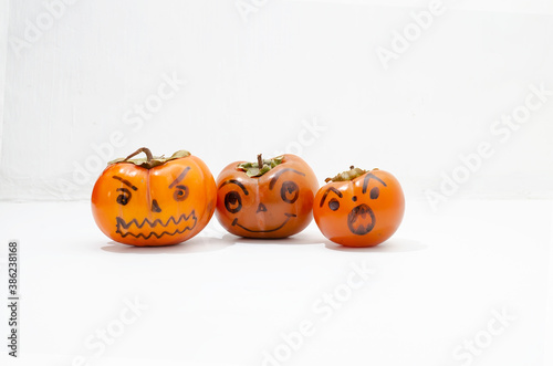 Jack - o ' - lantern, Halloween monsters - muzzles drawn on persimmon fruit. Persimmon is very similar to a pumpkin, the same orange and cheerful. © SolaraLife888