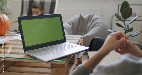 Woman holding computer with green screen