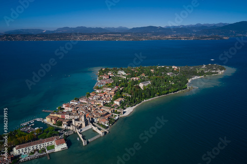 Top view of the town of Sirmione, Italy. Trees in the autumn season. Lake Garda, a tourist destination in northern Italy. Autumn in Italy on Lake Garda, Sirmione peninsula.
