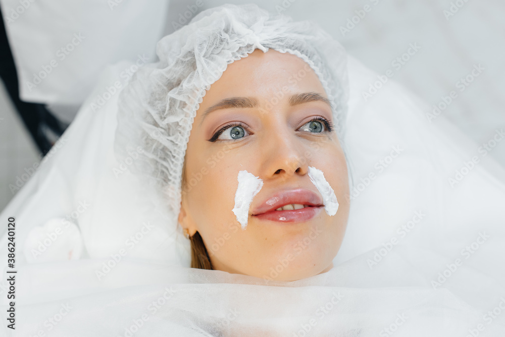 Moisturizing the lips during a cosmetic procedure for a young girl. Cosmetology Moisturizing the lips during a cosmetic procedure for a young girl. Cosmetology