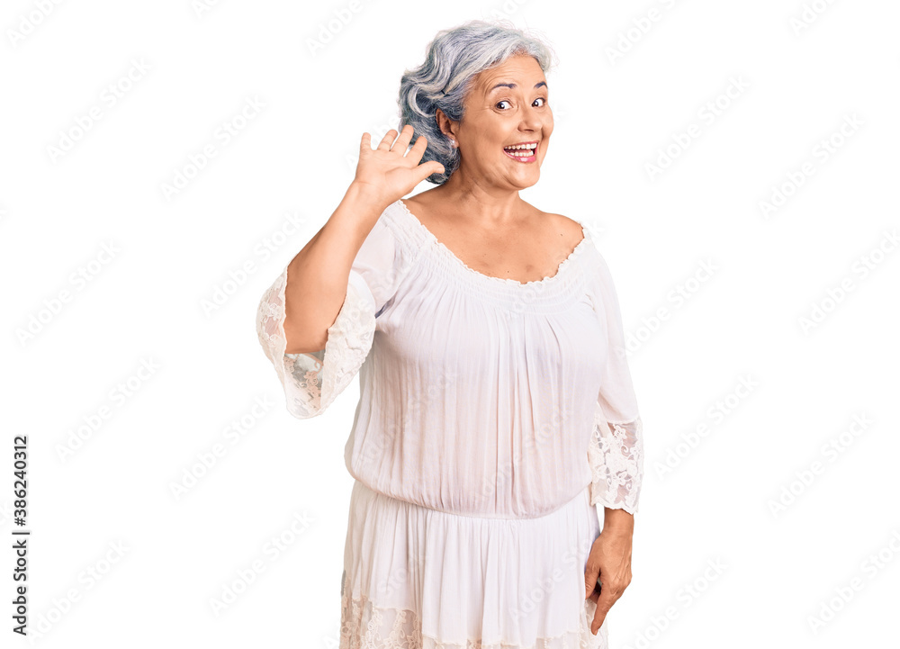 Senior woman with gray hair wearing bohemian style waiving saying hello happy and smiling, friendly welcome gesture Senior woman with gray hair wearing bohemian style waiving saying hello happy and smiling, friendly welcome gesture